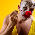 sad-clown-putting-on-makeup-GettyImages-2187826511